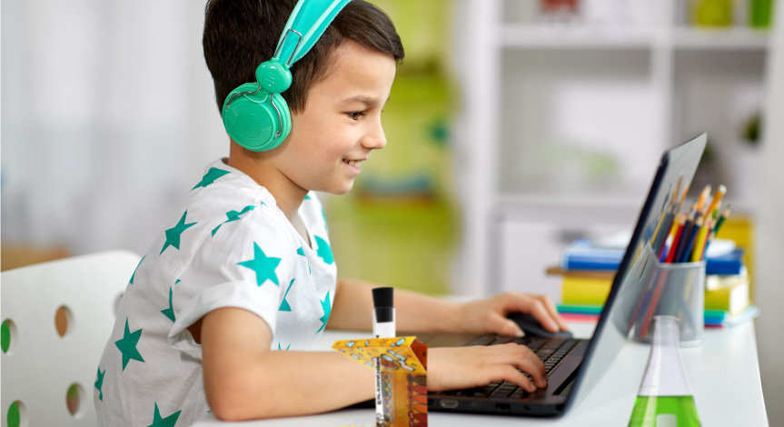 Boy performing a Mad Science Virtual class sitting in front of his computer
